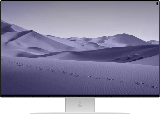 laptop screen displaying an isolated desert landscape with footprints in the sand