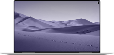 Laptop mit Wüstenlandschaft auf dem Bildschirm und Sanddünen im Vordergrund.